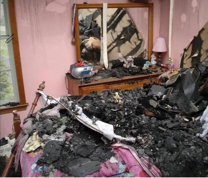 bedroom full of fire damaged debris