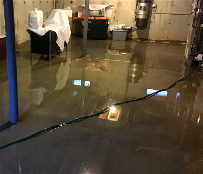 an unfinished flooded basement. About 1 inch of water across entire concrete floor