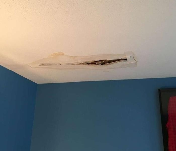 water damage ceiling. there is water stain as well as a hole in the ceiling where water leaked through