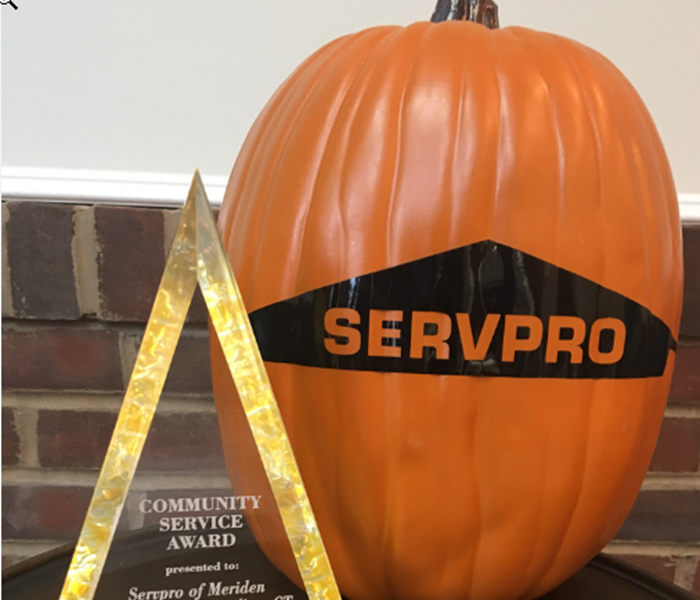 Pumpkin with SERVPRO logo on table next to award