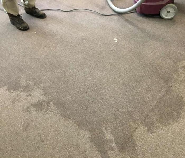 technicians feet on corner of water stained carpet with shop vac